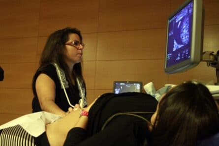 Doctora Gomar realizando ecografía a paciente